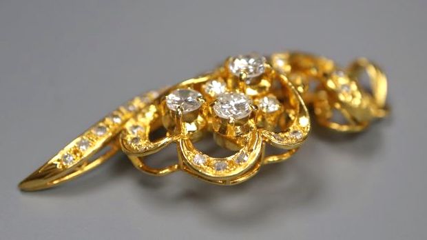 A modern yellow metal (stamped 8k) and diamond set foliate spray pendant, 40mm, gross 5.7grams.